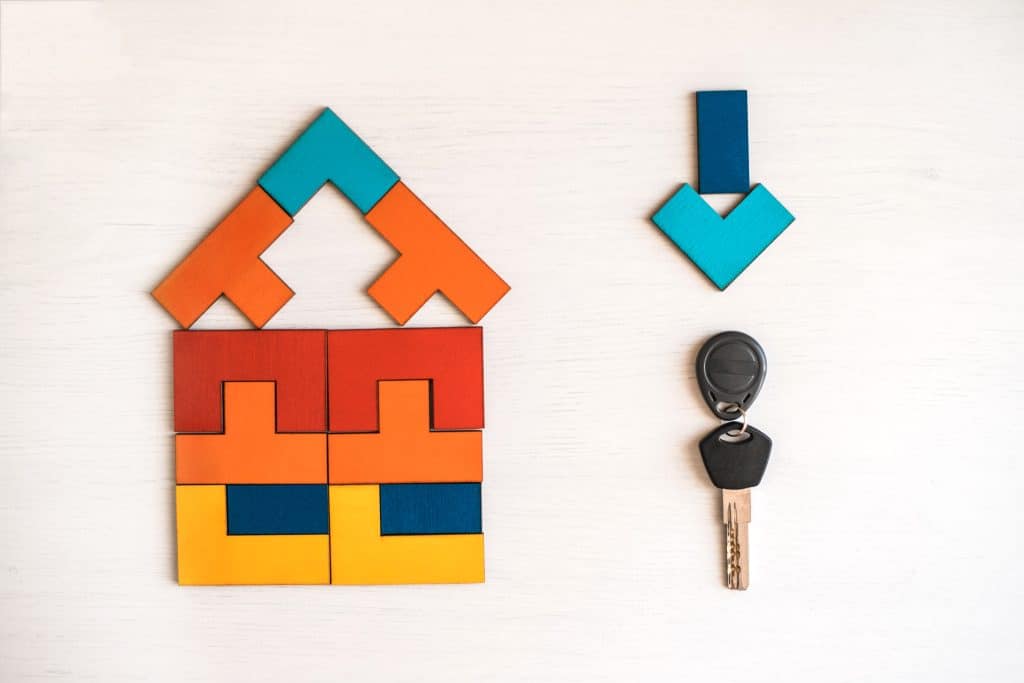 Model,House,Made,From,Wooden,Puzzle,With,Key,On,White